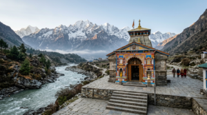 Badrinath Temple painted facade and arched gateway below snow-capped Neelkanth peak
